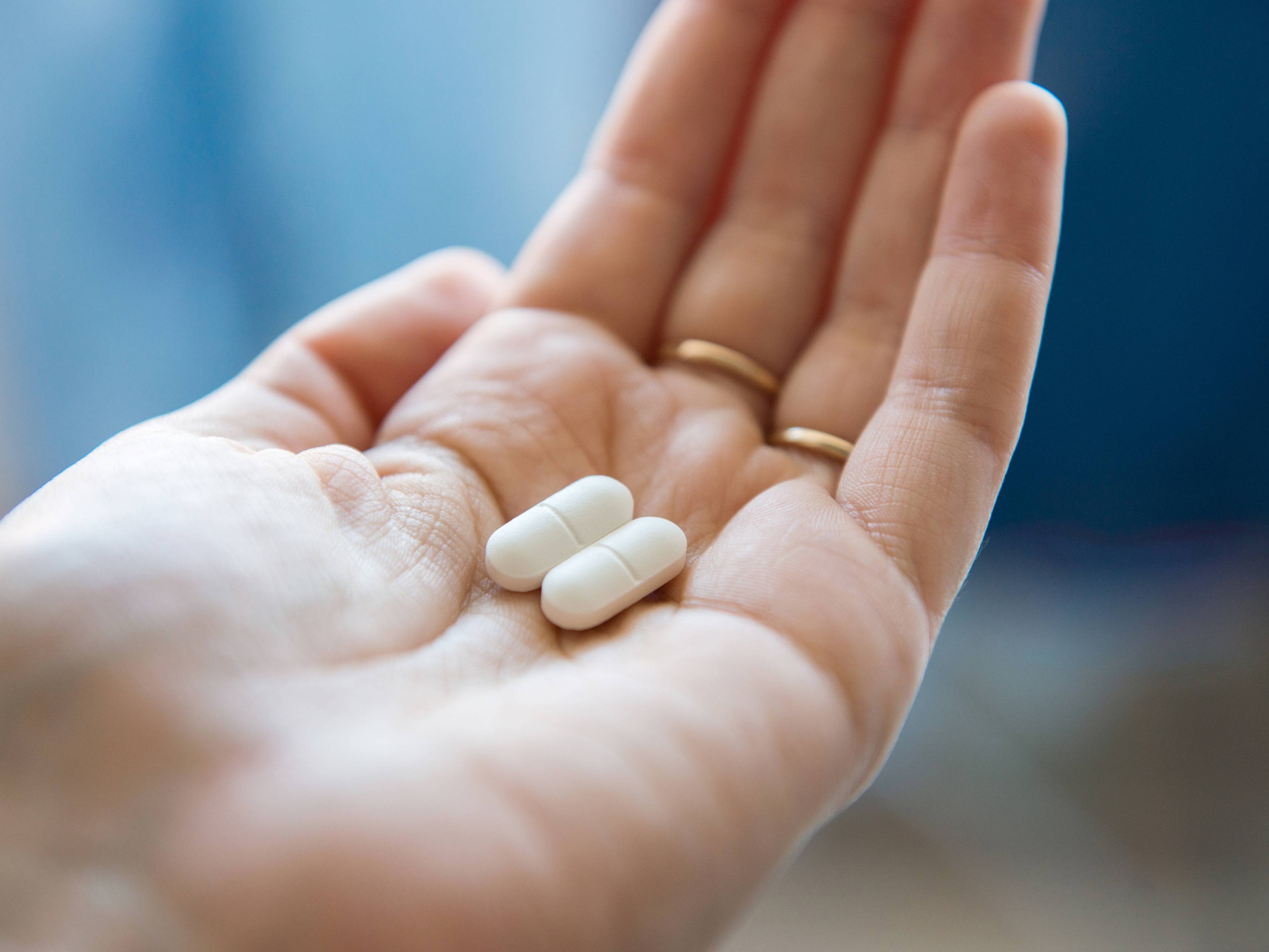 Eine Hand mit zwei Tabletten in der Handfläche.