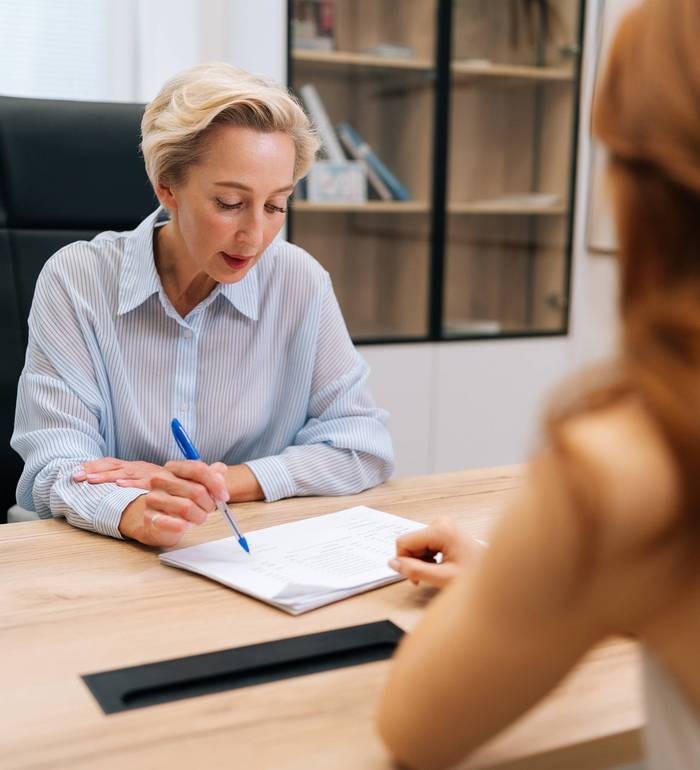 Symbolbild: Zwei Frauen sitzen am Tisch in einer Beratungssituation.