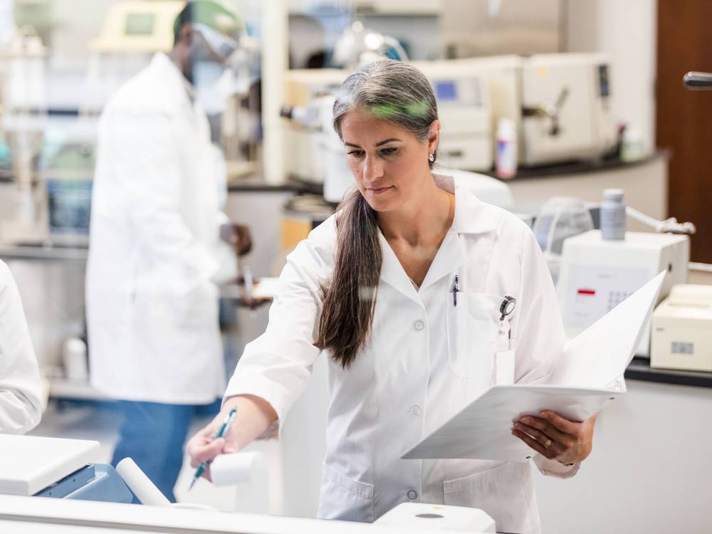 Mitarbeiterin in einem weißen Kittel in einem Forschungslabor eines Unternehmens