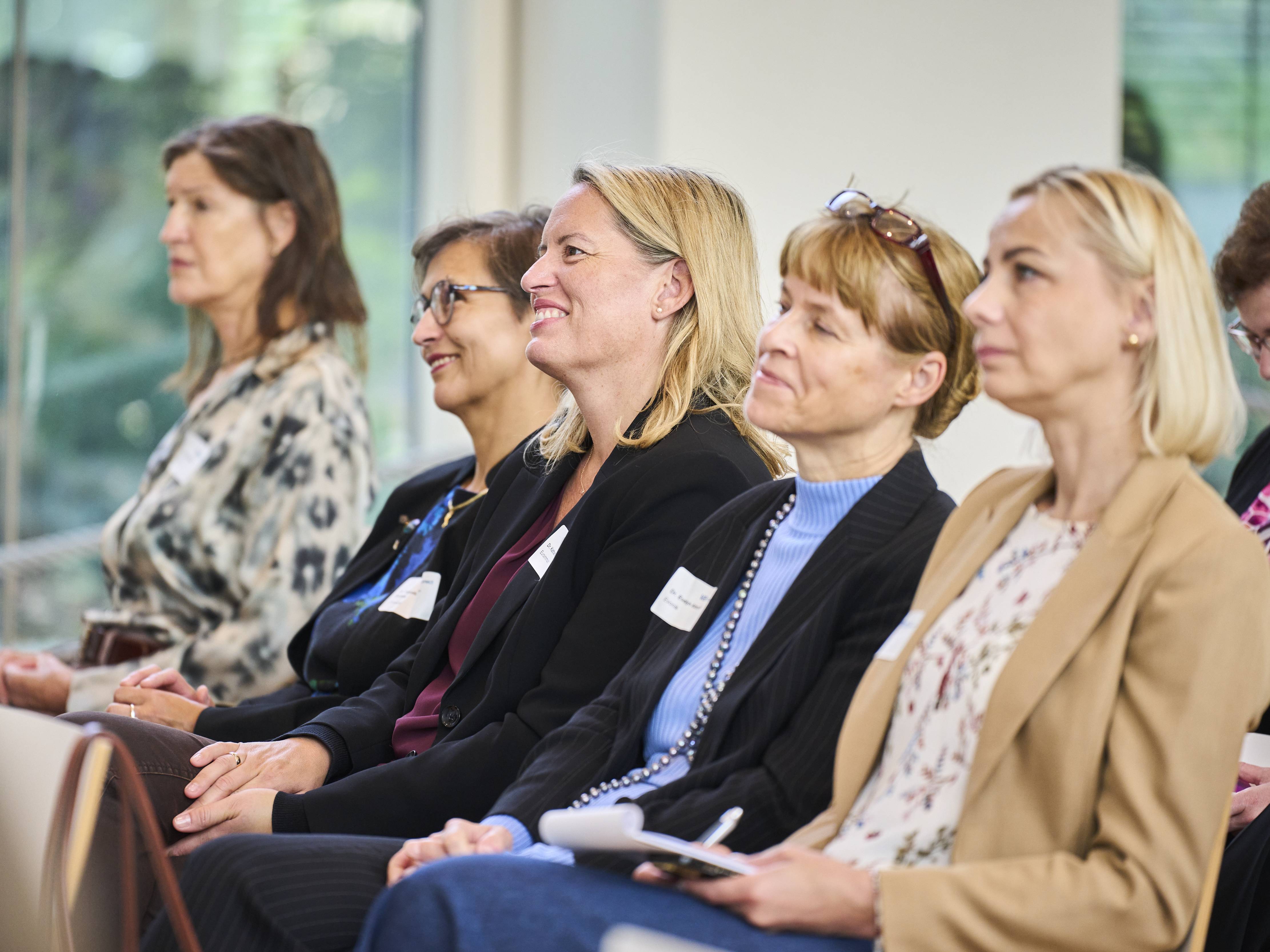 Teilnehmerinnen hören zu.