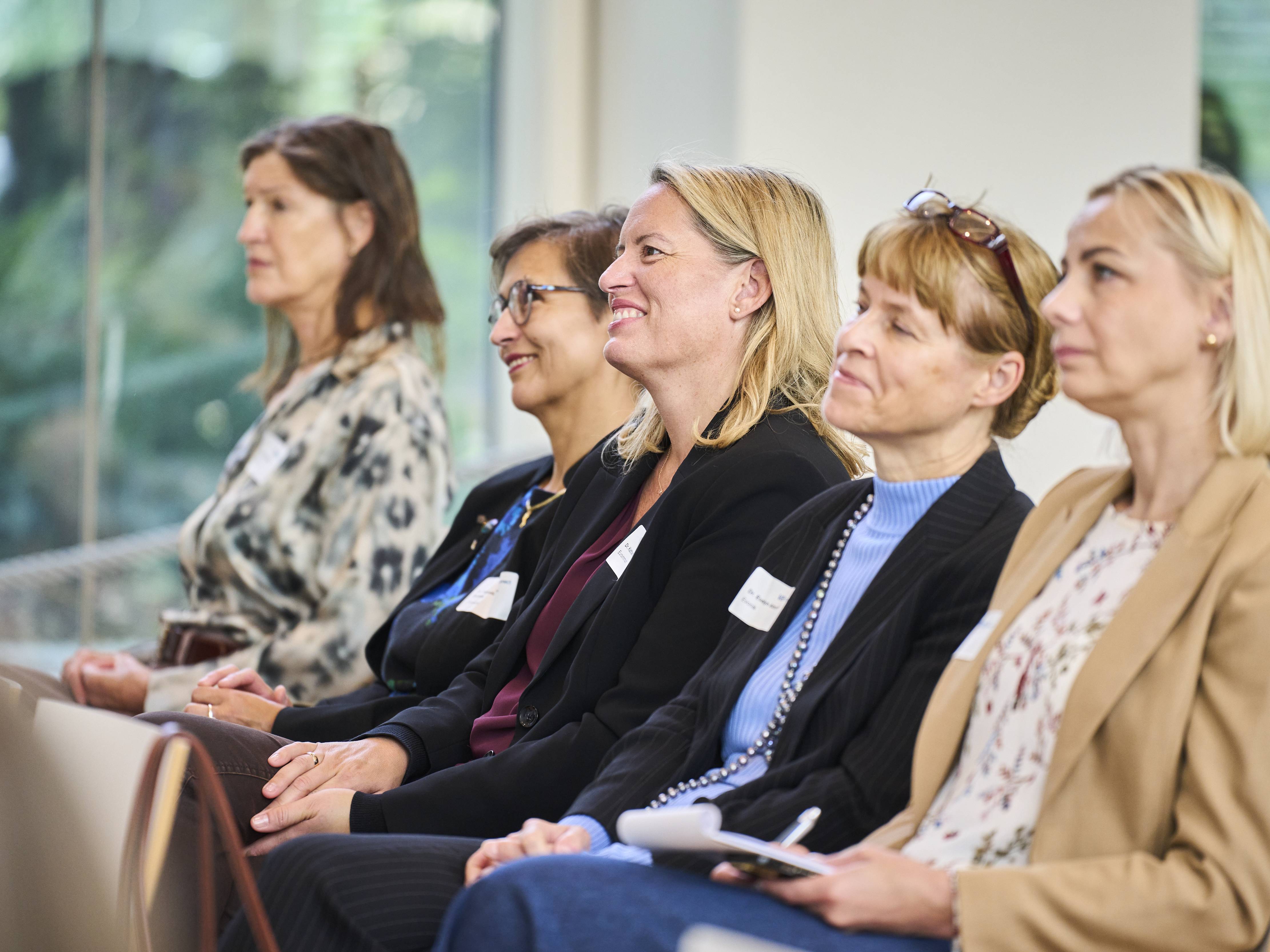 Teilnehmerinnen hören zu.