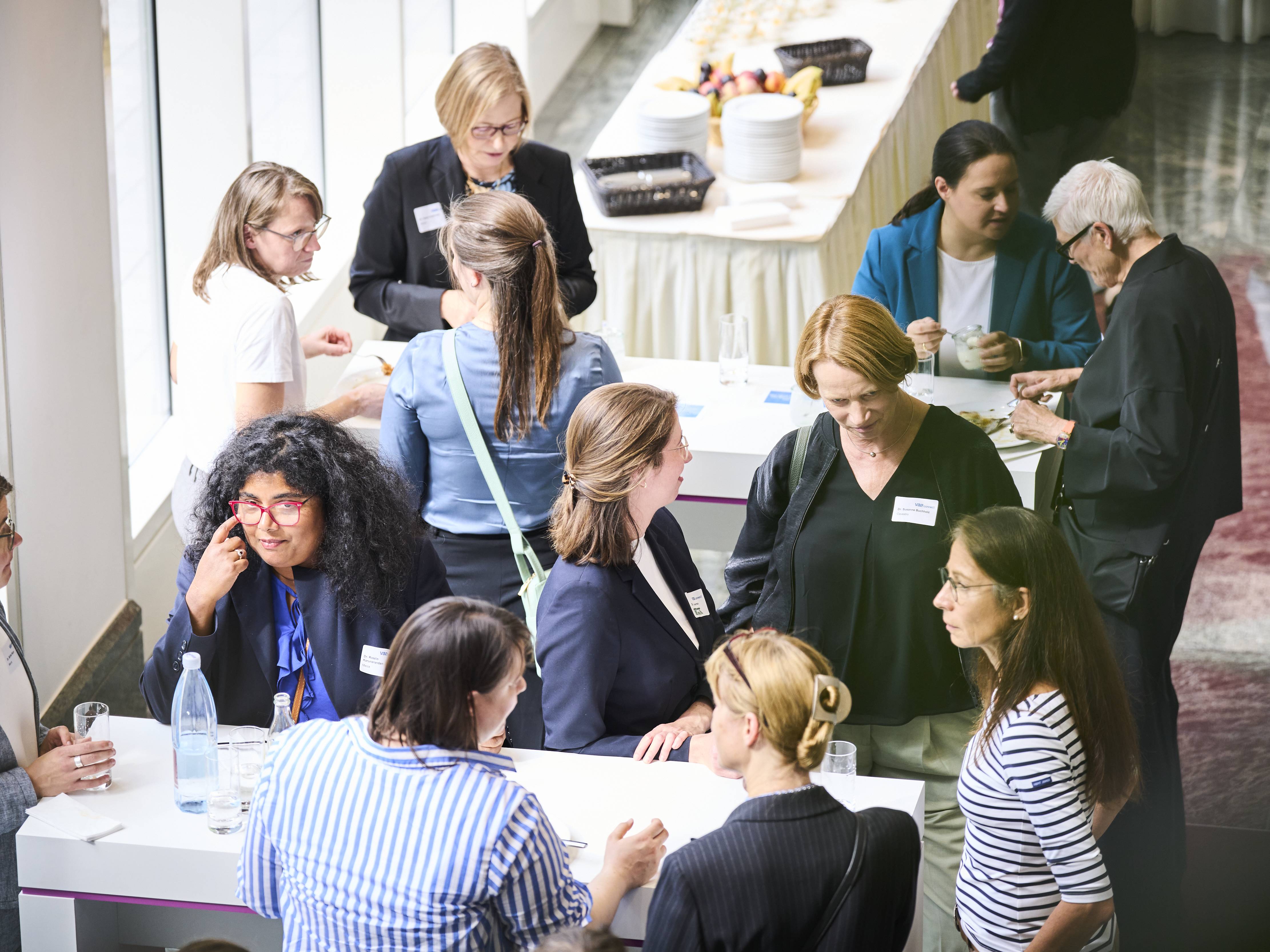 Teilnehmerinnen an Stehtischen beim Networking.