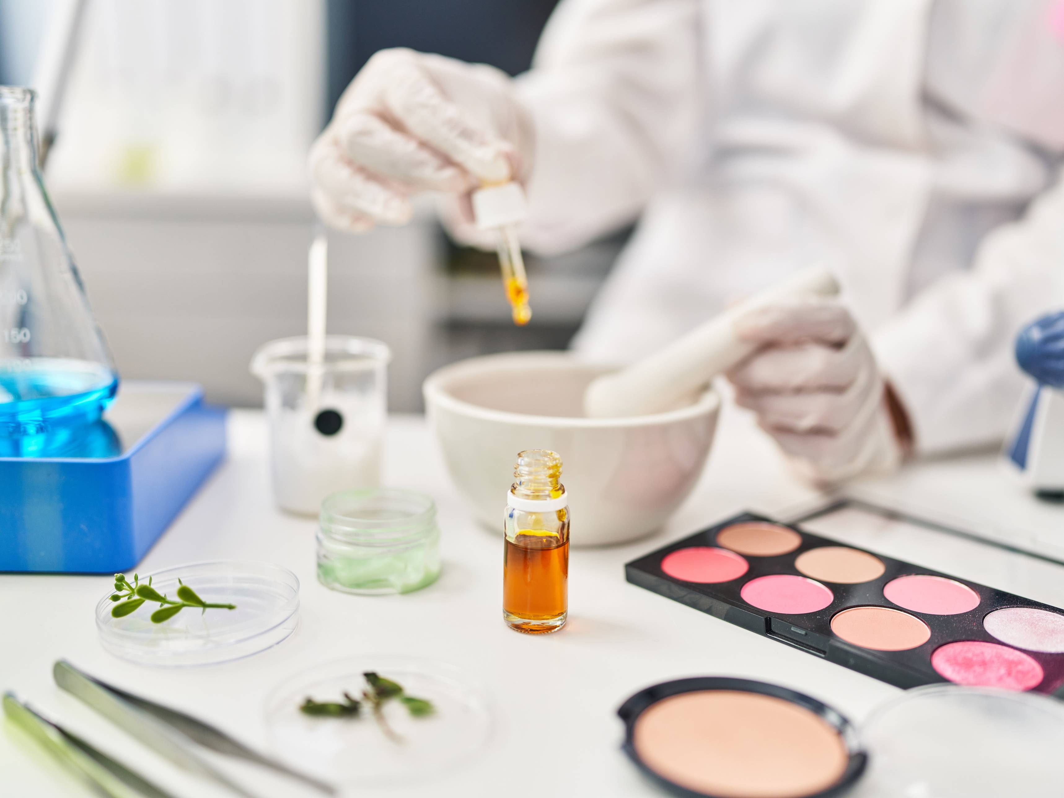 Eine Schminkpalette und ein Puder wird mithilfe von anderen Flüssigkeiten untersucht.